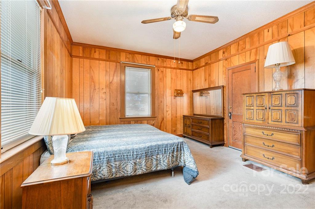 8209 Moores Chapel Road Charlotte, NC 28214 - Photo 23 of 32 a bedroom with a bed and a chandelier