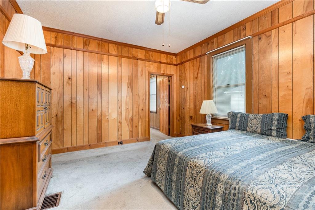 8209 Moores Chapel Road Charlotte, NC 28214 - Photo 24 of 32 a bedroom with a large bed and a chandelier