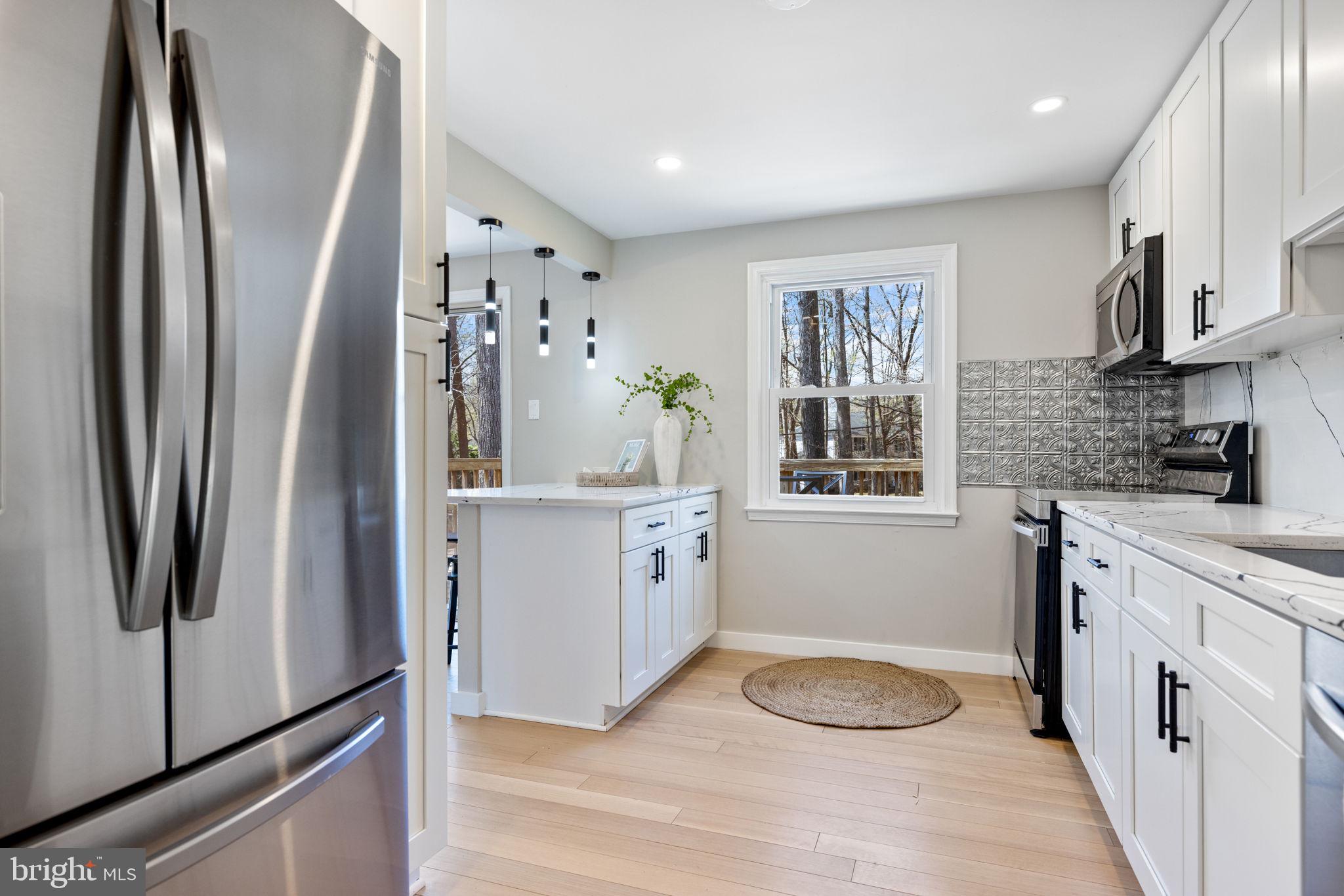 12870 Graypine Place Herndon, VA 20170 - Photo 5 of 35 a kitchen with white cabinets and refrigerator