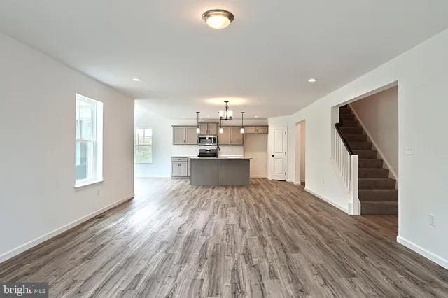 a view of a kitchen with wooden floor and a window