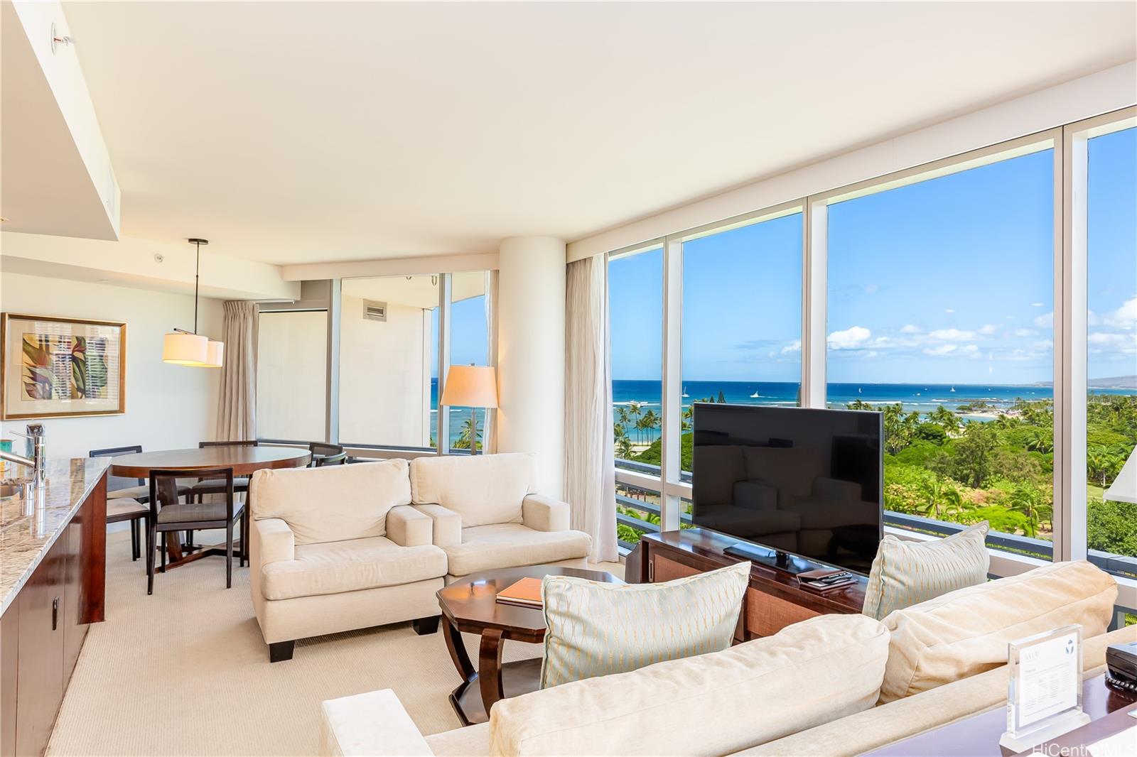223 Saratoga Road, Unit 1203 Honolulu, HI 96815 - Photo 1 of 1 a living room with furniture a large window and a flat screen tv