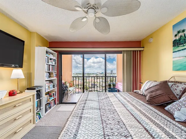 a spacious bedroom with a large bed and a chandelier