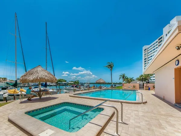 a swimming pool with outdoor seating and a garden
