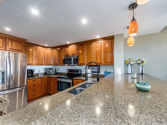 a kitchen with sink a refrigerator and chairs