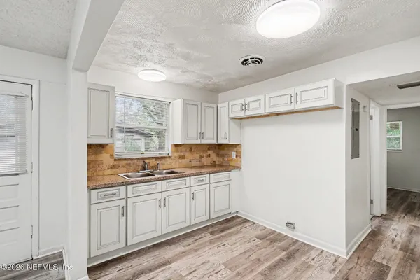 a view of empty room with wooden floor