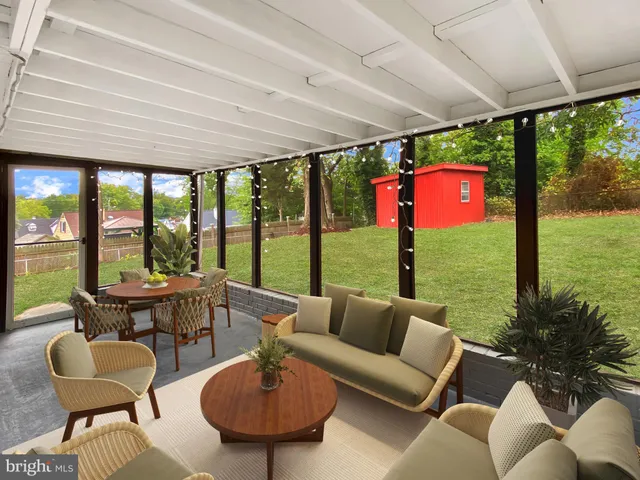a living room with patio furniture and a floor to ceiling window