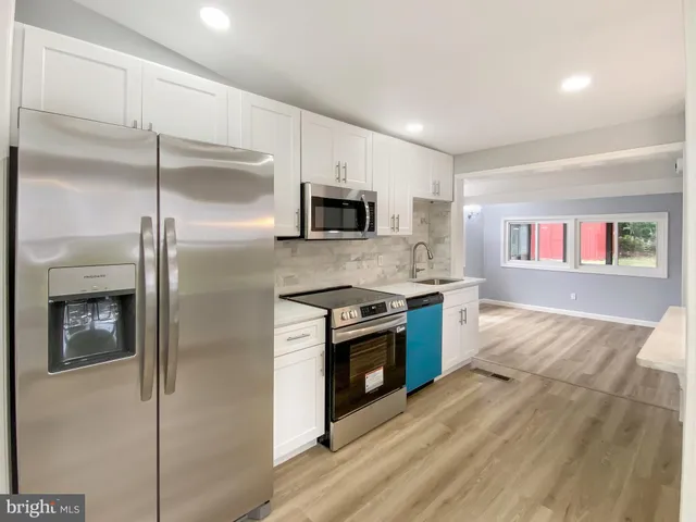 a kitchen with stainless steel appliances granite countertop a refrigerator and a stove top oven