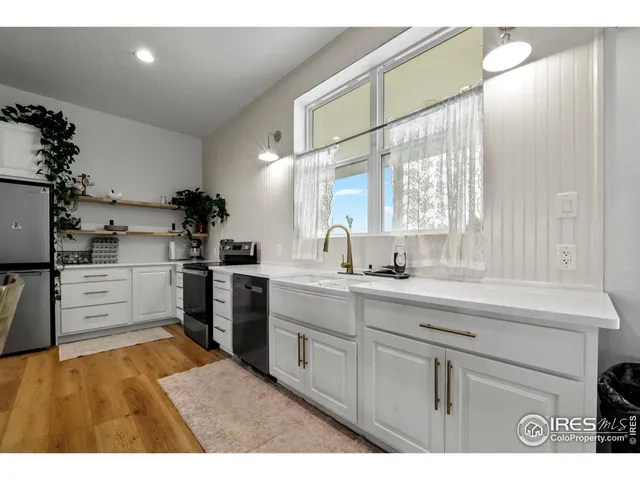 a kitchen with white cabinets and appliances