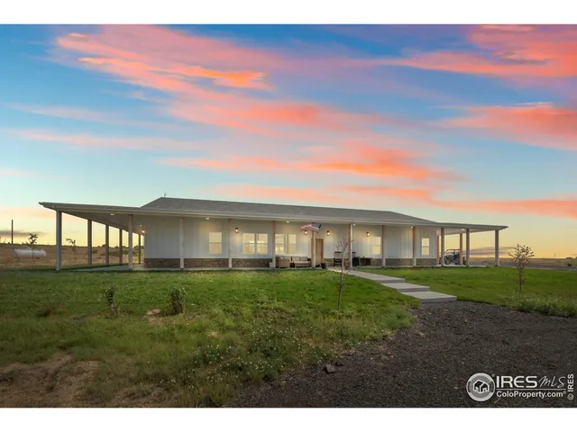 a view of a big house with a big yard and large trees