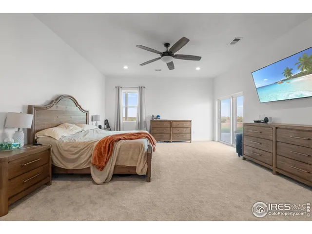 a spacious bedroom with a bed and dresser