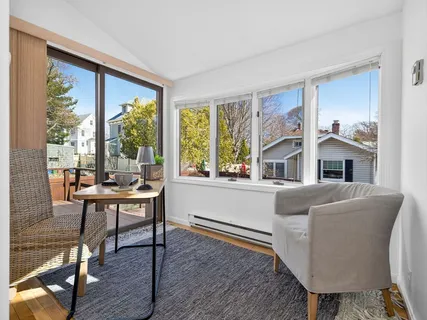 a living room with furniture a large window and wooden floor