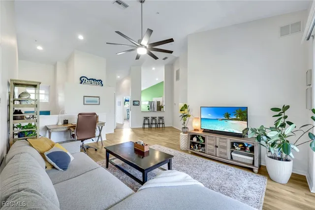 a living room with furniture potted plant and a chandelier