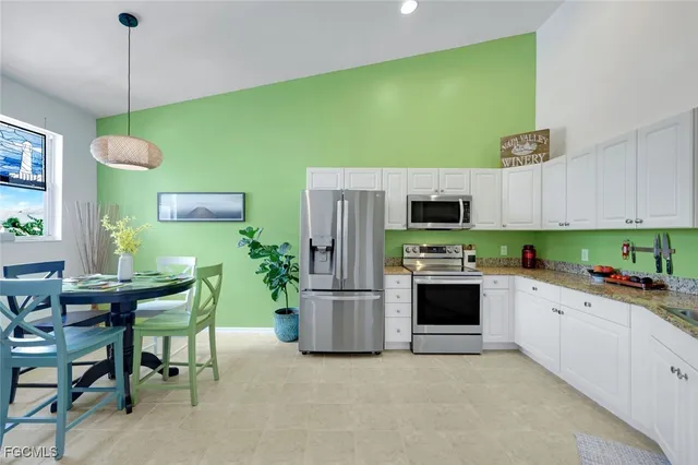 a kitchen with stainless steel appliances kitchen island a table and chairs in it