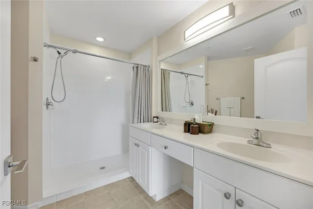 a bathroom with a double vanity sink mirror and shower