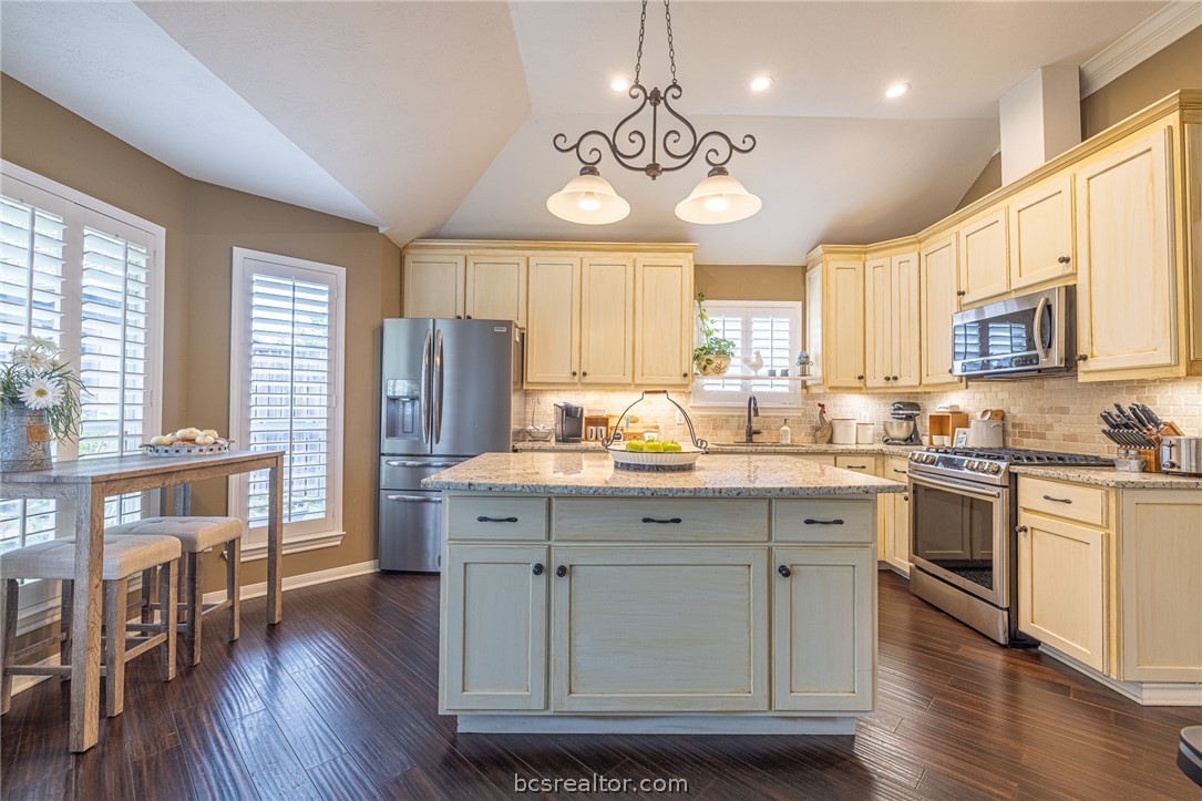 2633 Trophy Drive Bryan, TX 77802 - Photo 11 of 47 a kitchen with stainless steel appliances granite countertop wooden floors and white cabinets