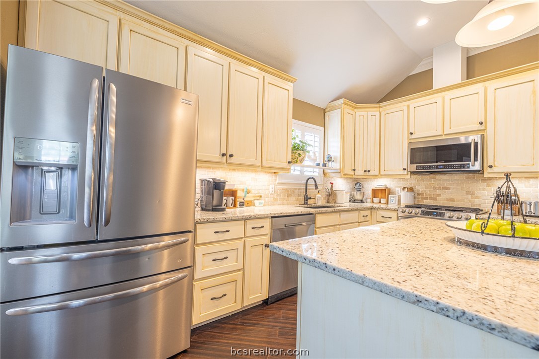 2633 Trophy Drive Bryan, TX 77802 - Photo 12 of 47 a kitchen with granite countertop a refrigerator stove and microwave