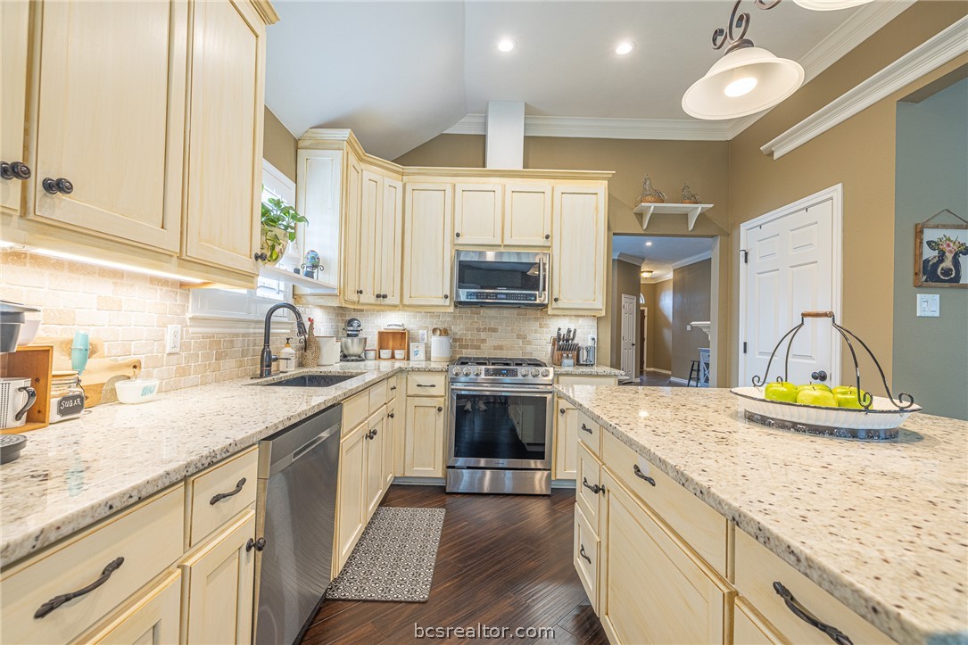2633 Trophy Drive Bryan, TX 77802 - Photo 13 of 47 a kitchen with stainless steel appliances granite countertop a sink stove and cabinets