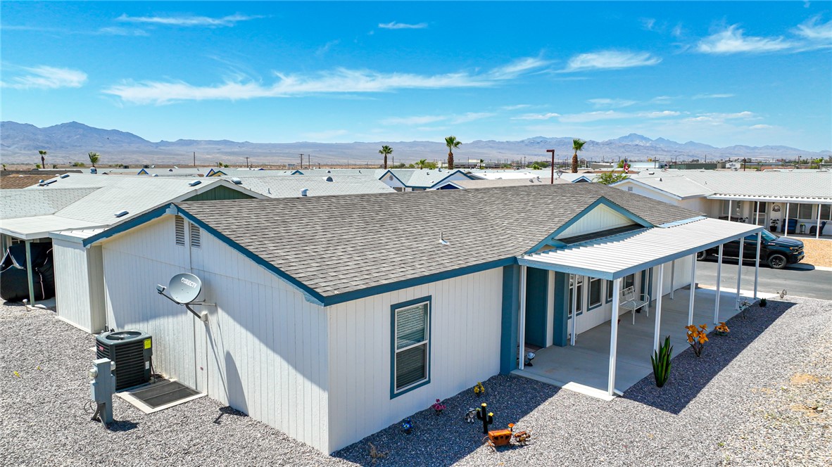 1545 El Rodeo Road Road, Unit 24 Fort Mohave, AZ 86426 - Photo 3 of 41 View of front of home featuring a shingled roof, a mountain view, and a porch