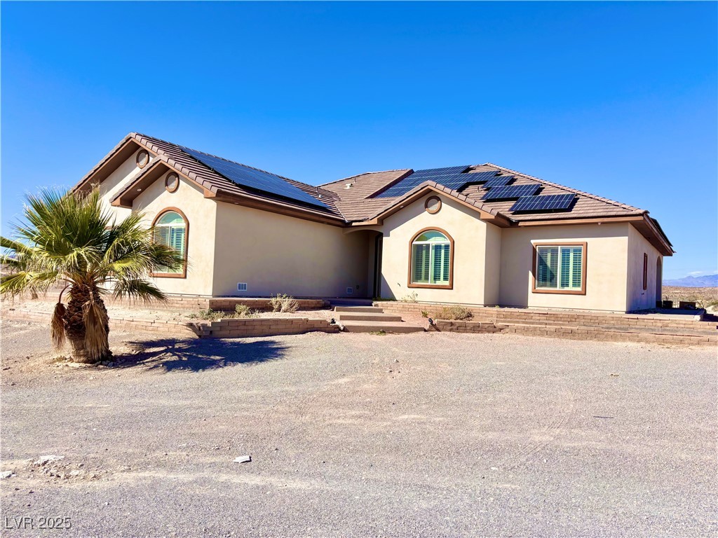 Mediterranean / spanish-style home with stucco siding and roof mounted solar panels