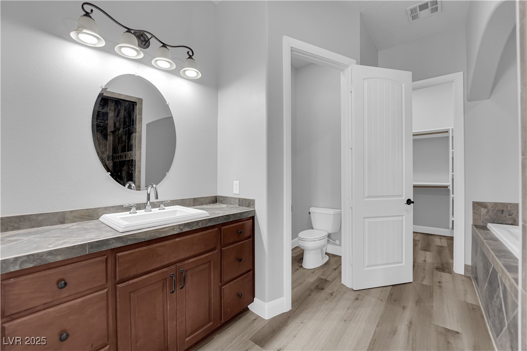 1415 Curohee Street Moapa, NV 89025 - Photo 27 of 54 Full bathroom featuring vanity, a garden tub, and light wood-style floors