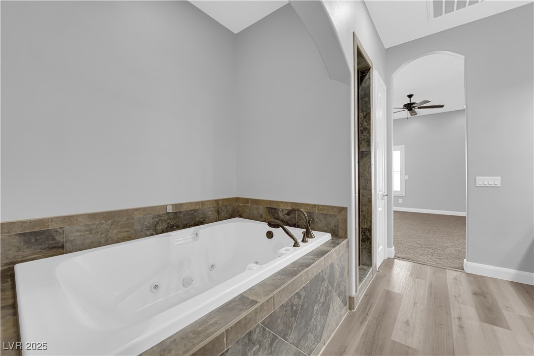 1415 Curohee Street Moapa, NV 89025 - Photo 30 of 54 Full bathroom featuring wood finished floors, a jetted tub, ceiling fan, and a stall shower