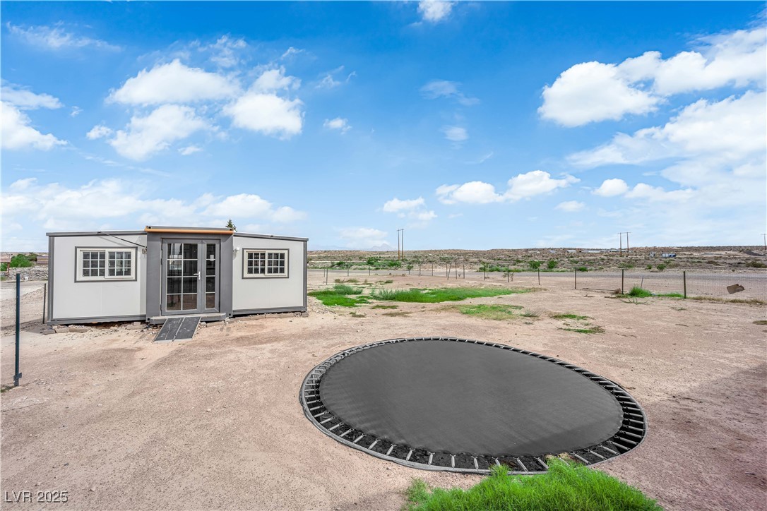 1415 Curohee Street Moapa, NV 89025 - Photo 37 of 54 Fenced backyard featuring an outdoor structure and a trampoline