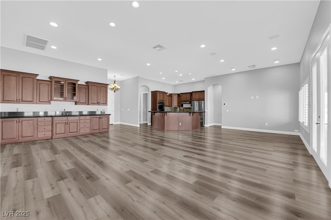1415 Curohee Street Moapa, NV 89025 - Photo 4 of 54 Unfurnished living room featuring arched walkways, recessed lighting, light wood-style floors, and a chandelier