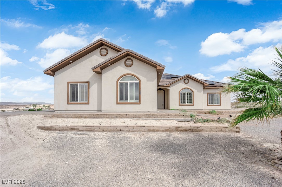1415 Curohee Street Moapa, NV 89025 - Photo 43 of 54 Mediterranean / spanish-style house with stucco siding, a tile roof, and solar panels