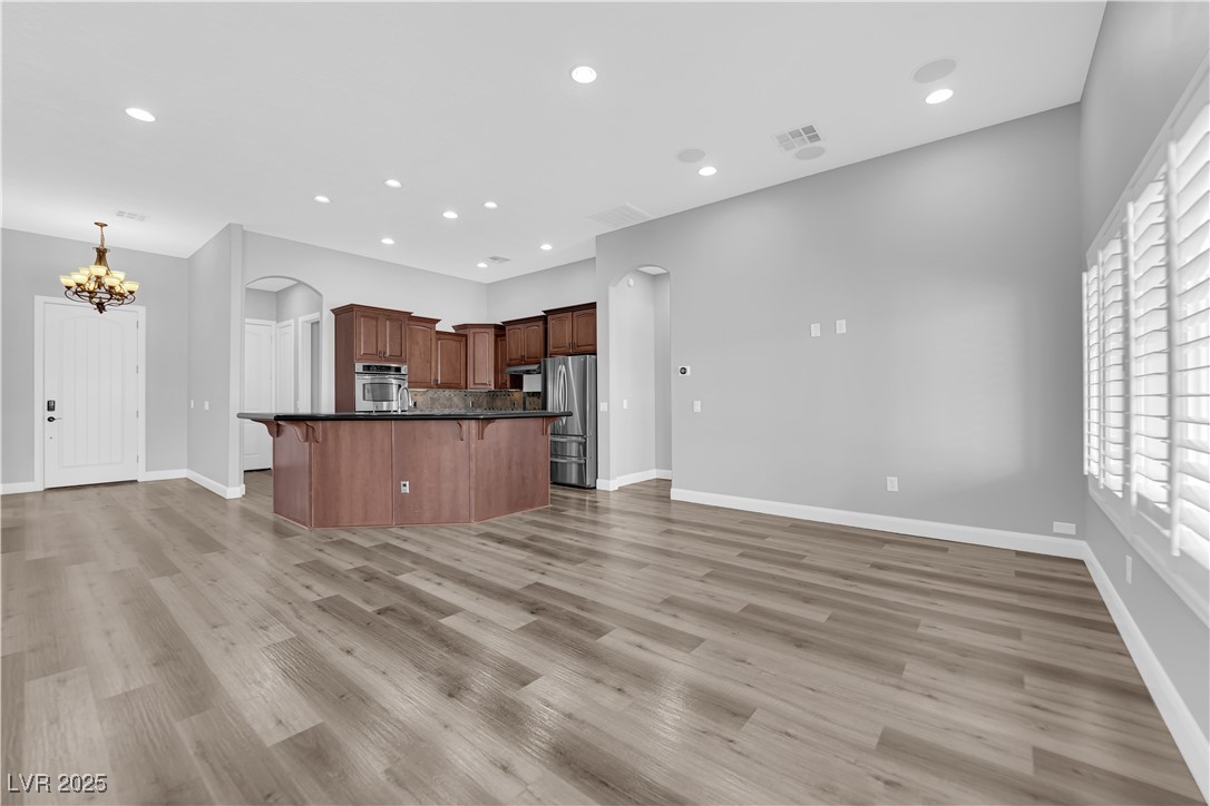1415 Curohee Street Moapa, NV 89025 - Photo 7 of 54 Kitchen featuring a breakfast bar area, arched walkways, stainless steel appliances, recessed lighting, and brown cabinets