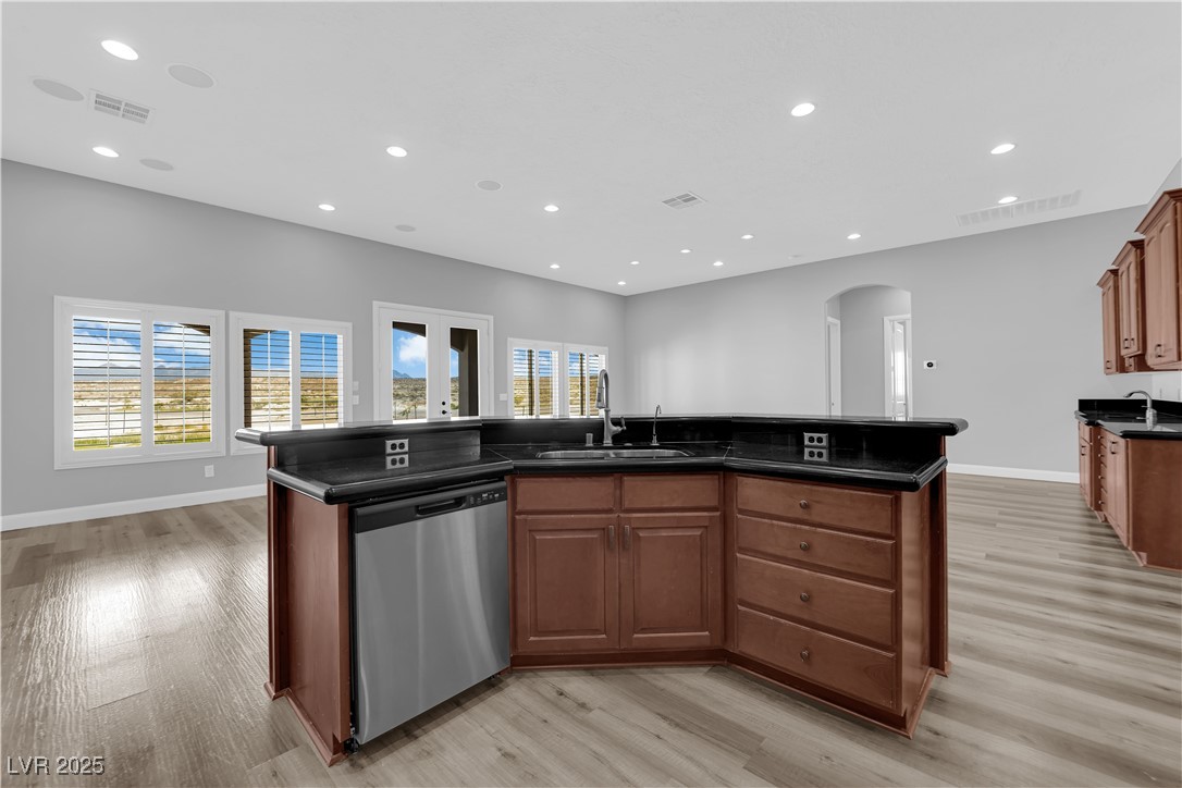 1415 Curohee Street Moapa, NV 89025 - Photo 8 of 54 Kitchen with an island with sink, arched walkways, recessed lighting, stainless steel dishwasher, and brown cabinetry