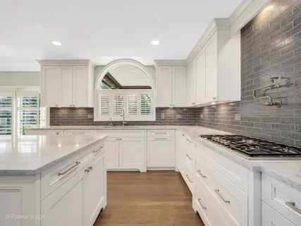 a kitchen with granite countertop a sink stove and cabinets