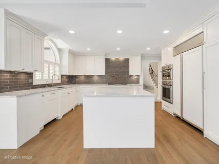 a large kitchen with stainless steel appliances kitchen island granite countertop a stove a sink and a refrigerator