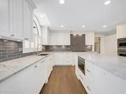 a large kitchen with stainless steel appliances granite countertop a sink and a stove