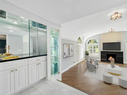 a living room with furniture a flat screen tv and large window