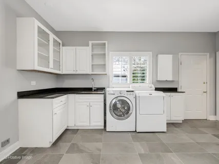 a utility room with sink dryer and washer