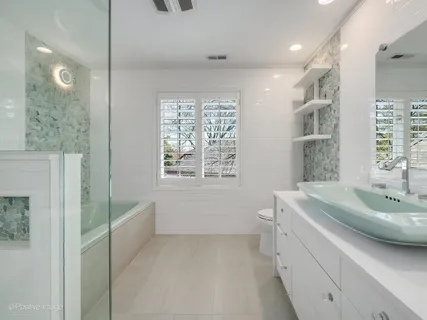 a spacious bathroom with a tub sink and mirror
