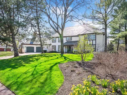 a front view of a house with a yard and potted plants