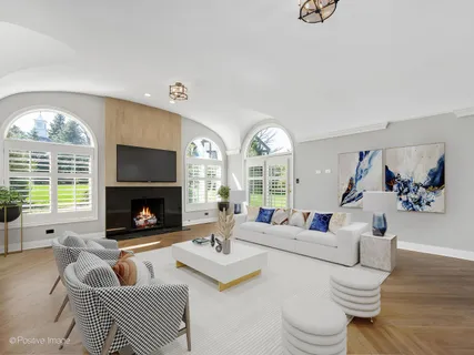 a living room with furniture fireplace and a large window