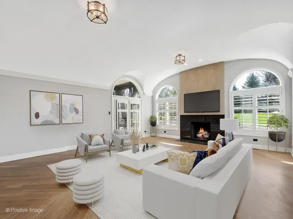 a living room with fireplace furniture and a large window