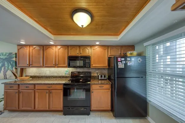 a kitchen with stainless steel appliances granite countertop a refrigerator a stove and a sink
