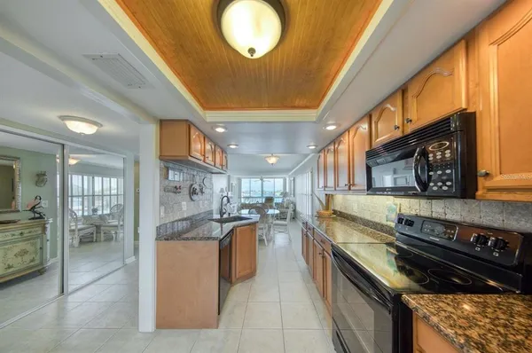 a large kitchen with stainless steel appliances granite countertop a stove and a sink
