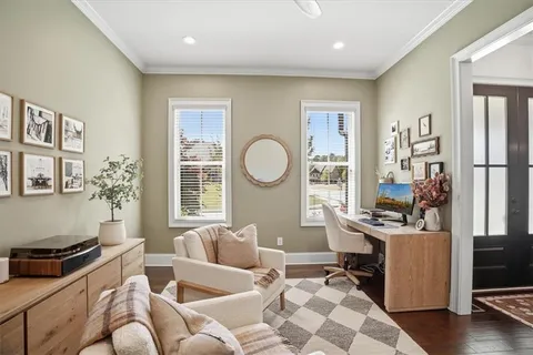 a view of a dining room and livingroom with furniture wooden floor a chandelier