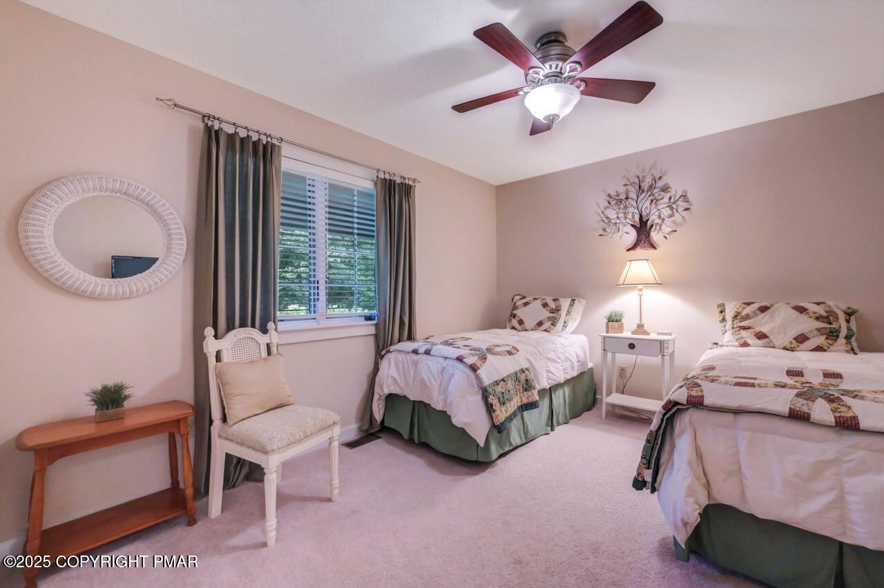 1179 Manor Hill Road Pocono Pines, PA 18350 - Photo 16 of 28 a spacious bedroom with a bed and a chandelier
