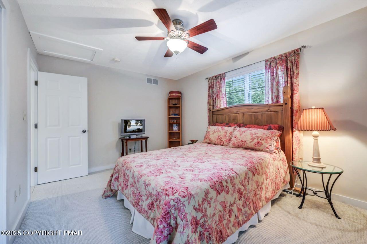 1179 Manor Hill Road Pocono Pines, PA 18350 - Photo 21 of 28 a bedroom with a large bed and a chandelier