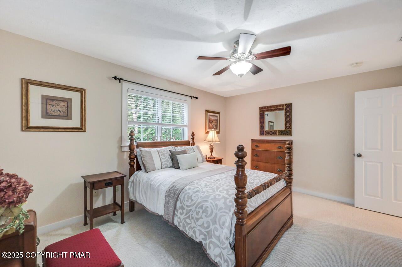 1179 Manor Hill Road Pocono Pines, PA 18350 - Photo 22 of 28 a bedroom with a bed and a chandelier