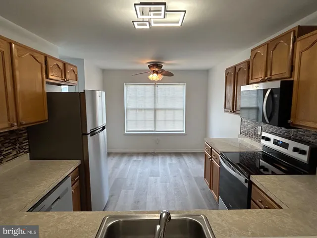 a kitchen with wooden floors and stainless steel appliances