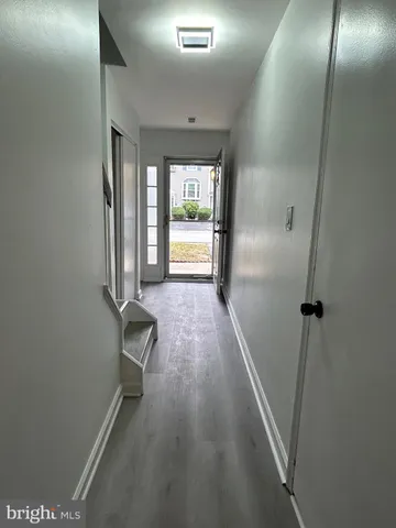 a view of a hallway with wooden floor and glass door