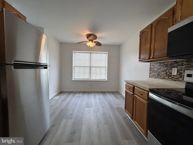 a kitchen with wooden floors a sink and a refrigerator