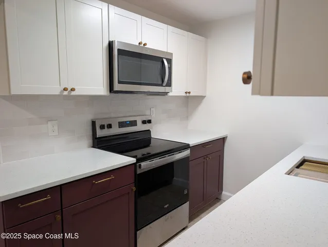a kitchen with a sink stove and microwave