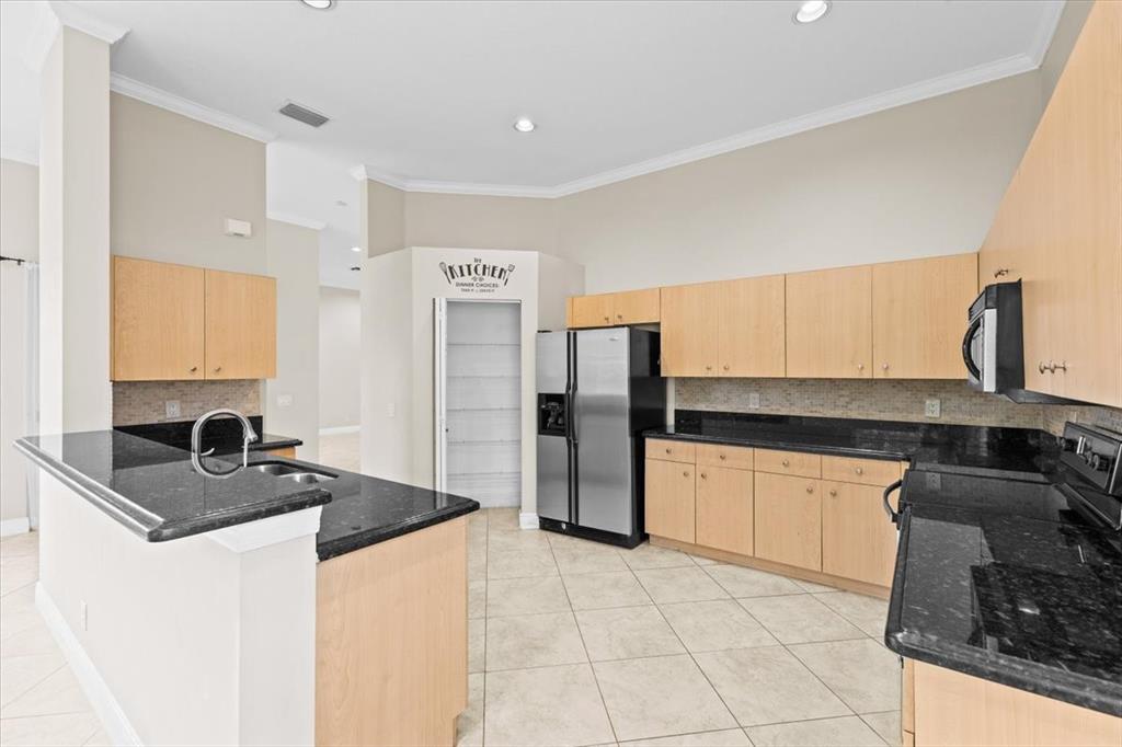 1441 Cardinal Way Weston, FL 33327 - Photo 18 of 96 a kitchen with granite countertop a sink a stove and refrigerator